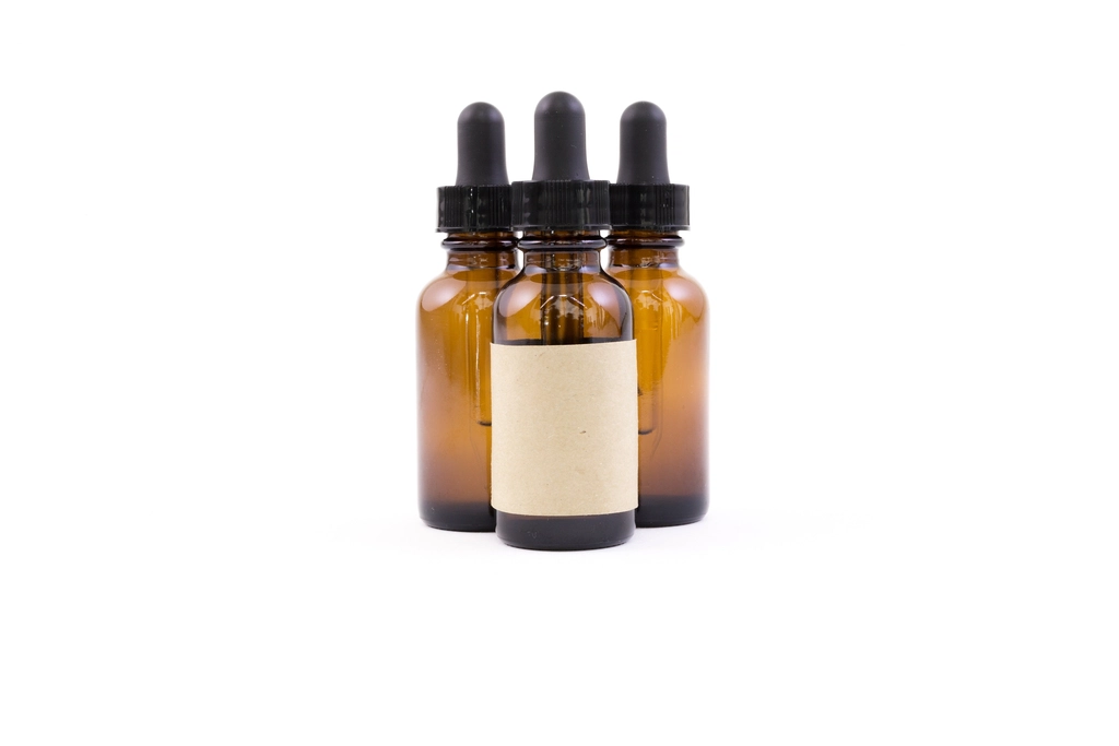 Three amber dropper bottles, one with a blank label